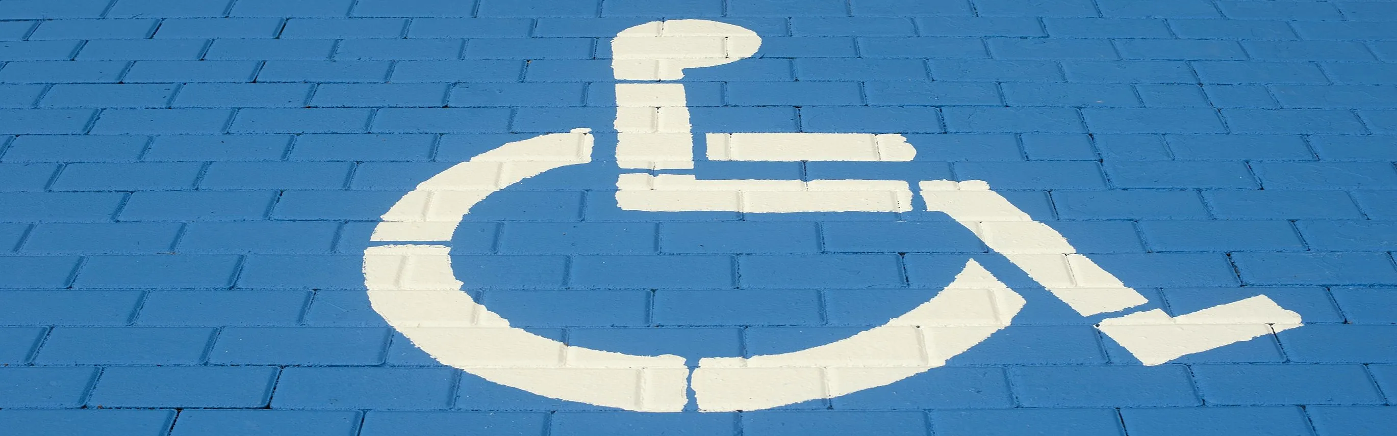 Weißes Rollstuhlsymbol auf blauem Boden